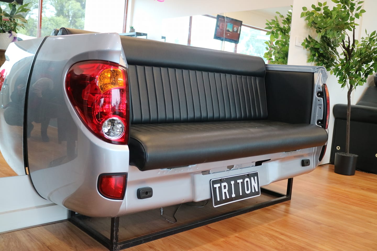 Couch made from the back of a silver Mitsubishi Triton ute, with a TRITON number plate